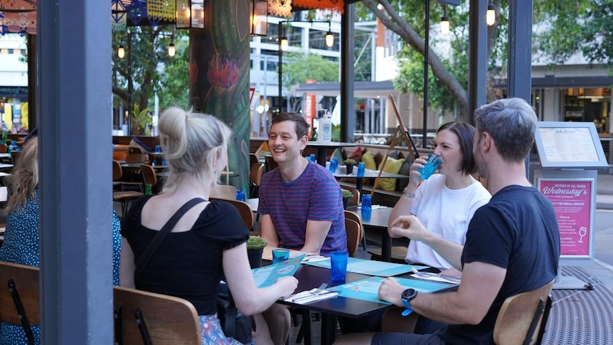 A group of people sit at a restaurant in Brisbane.
