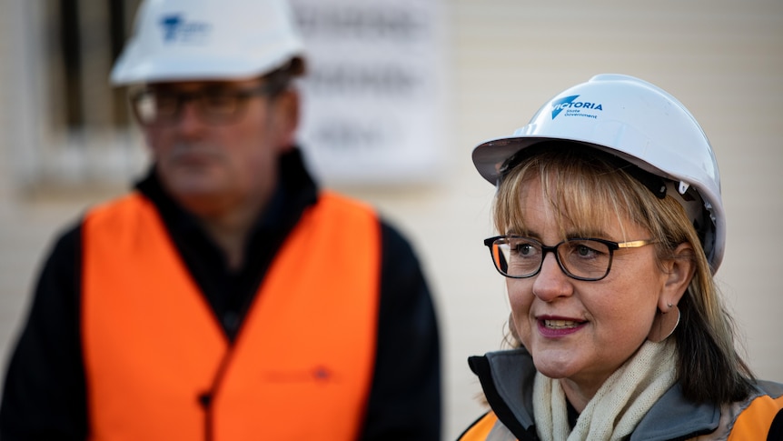 A woman and man in hard hats and high vis vests