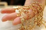 Gold jewellery draped over a  hand
