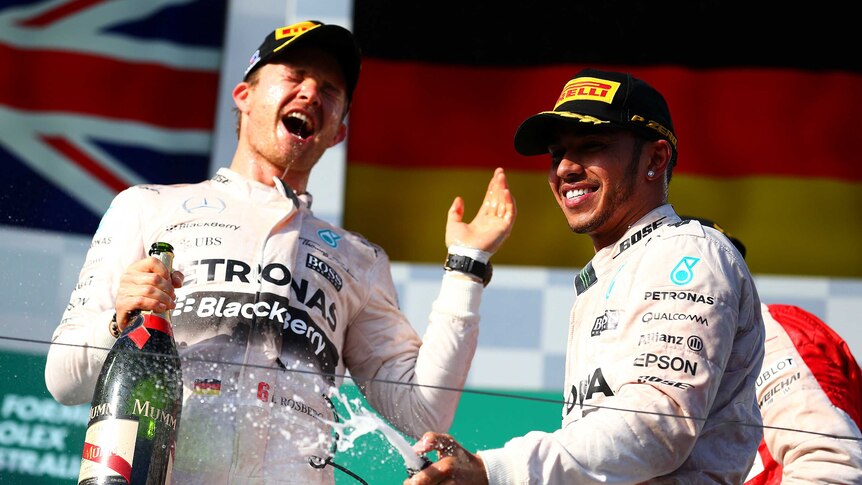 Lewis Hamilton celebrates on podium with Nico Rosberg