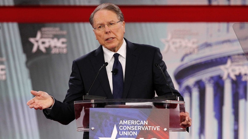 Wayne LaPierre speaks at a lectern, gesturing with one hand.