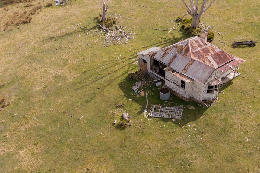 Drone shot of house from above, shows one wall missing