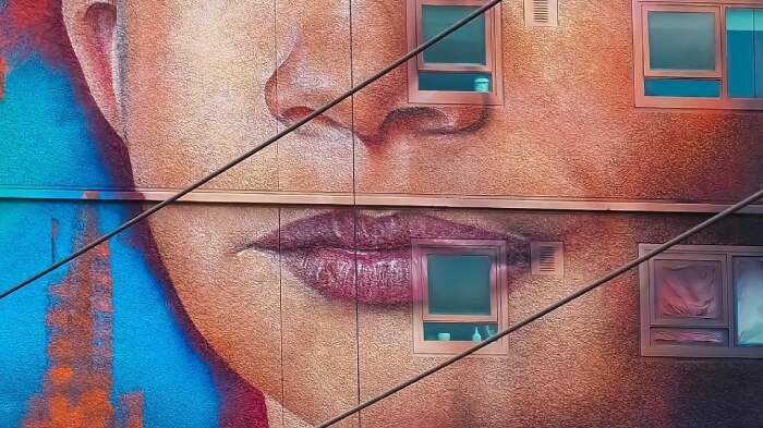 A mural of a young child's face on a building.