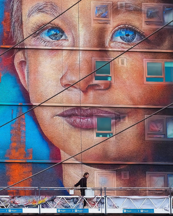 A mural of a young child's face on a building.