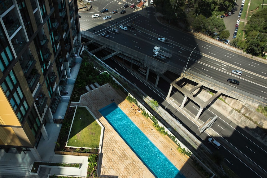 A busy motorway and an apartment tower, as seen from above