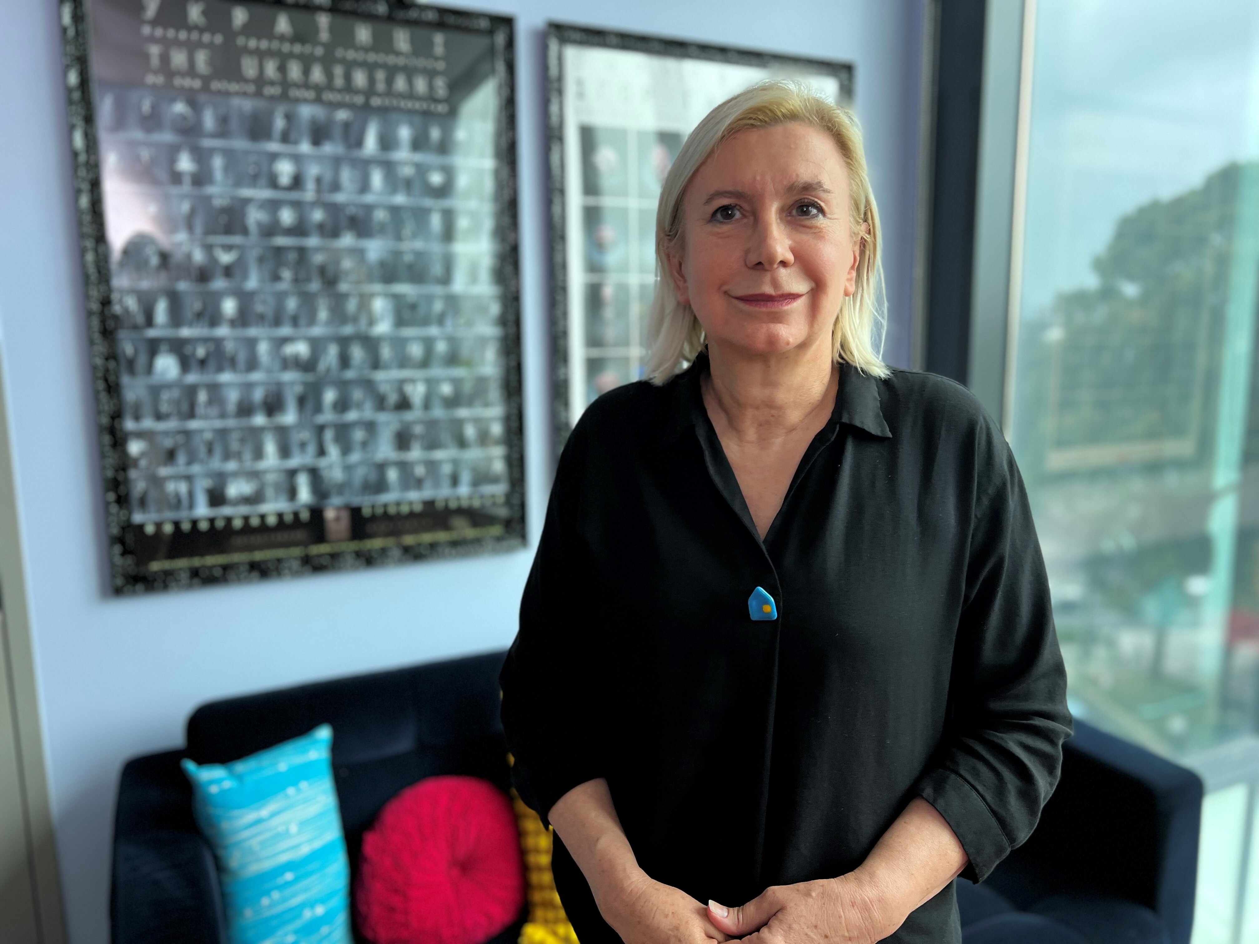 Dr Tanya Dus with a black button-down shirt and blonde hair