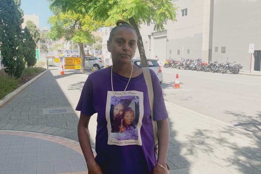 A woman wearing a t-shirt featuring the image of a woman on it and the words 'rest in peace'