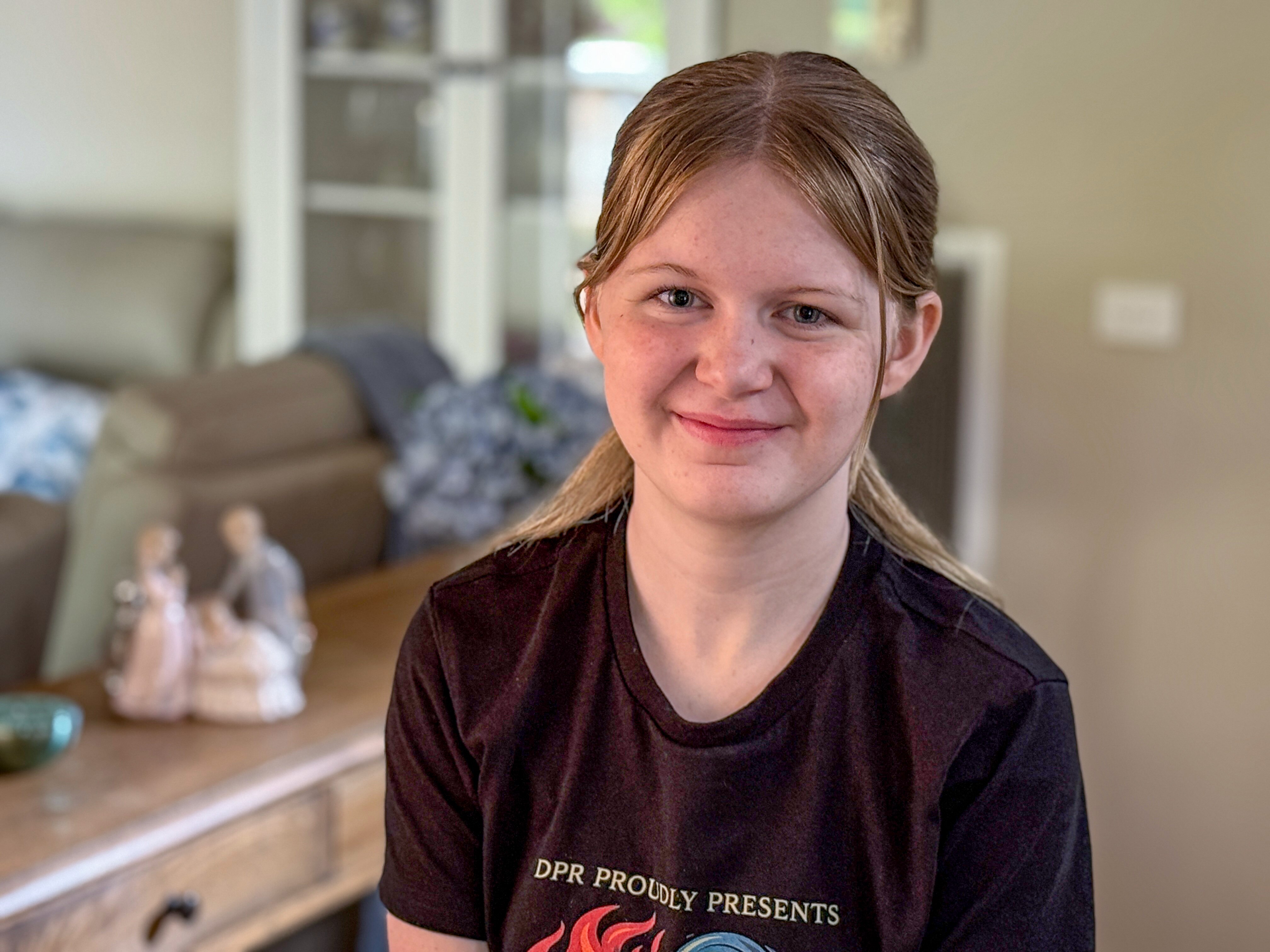 Una joven con una camiseta negra sonríe