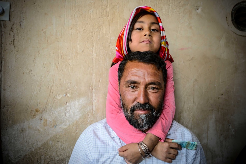 A father and his daughter in Iran stare into Sebastian Rich's lens