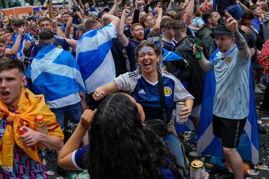 Scotland fans dance and smile in the street