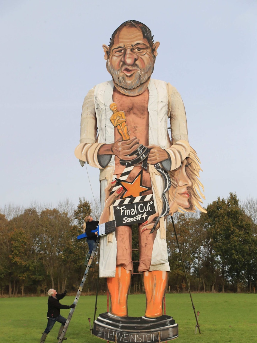 Artists put the final touches on an 11-metre tall Harvey Weinstein effigy.