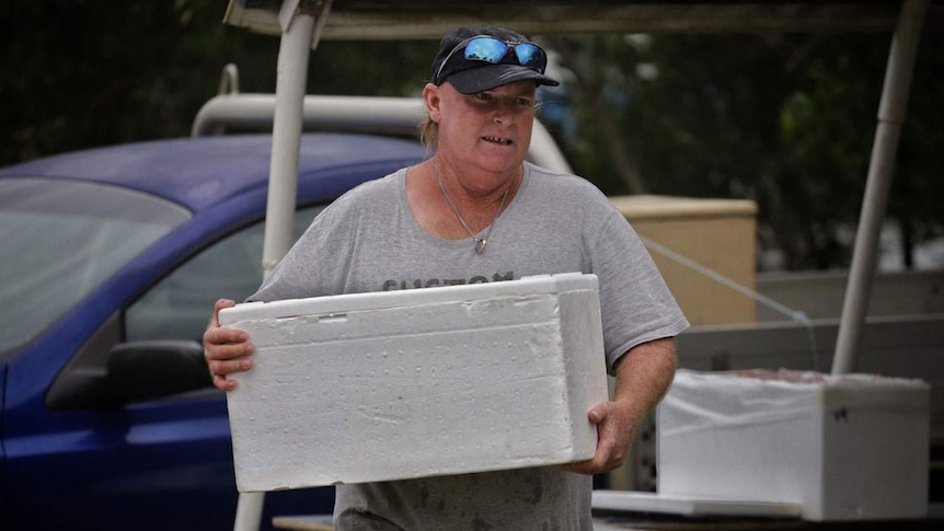 Daryl Davis carries box of seafood.