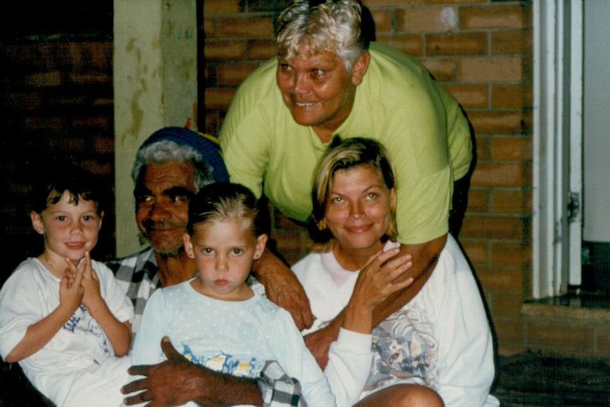 Aboriginal grandfather cuddles his grandaughters, Aborignal grandmother cuddles her daughter