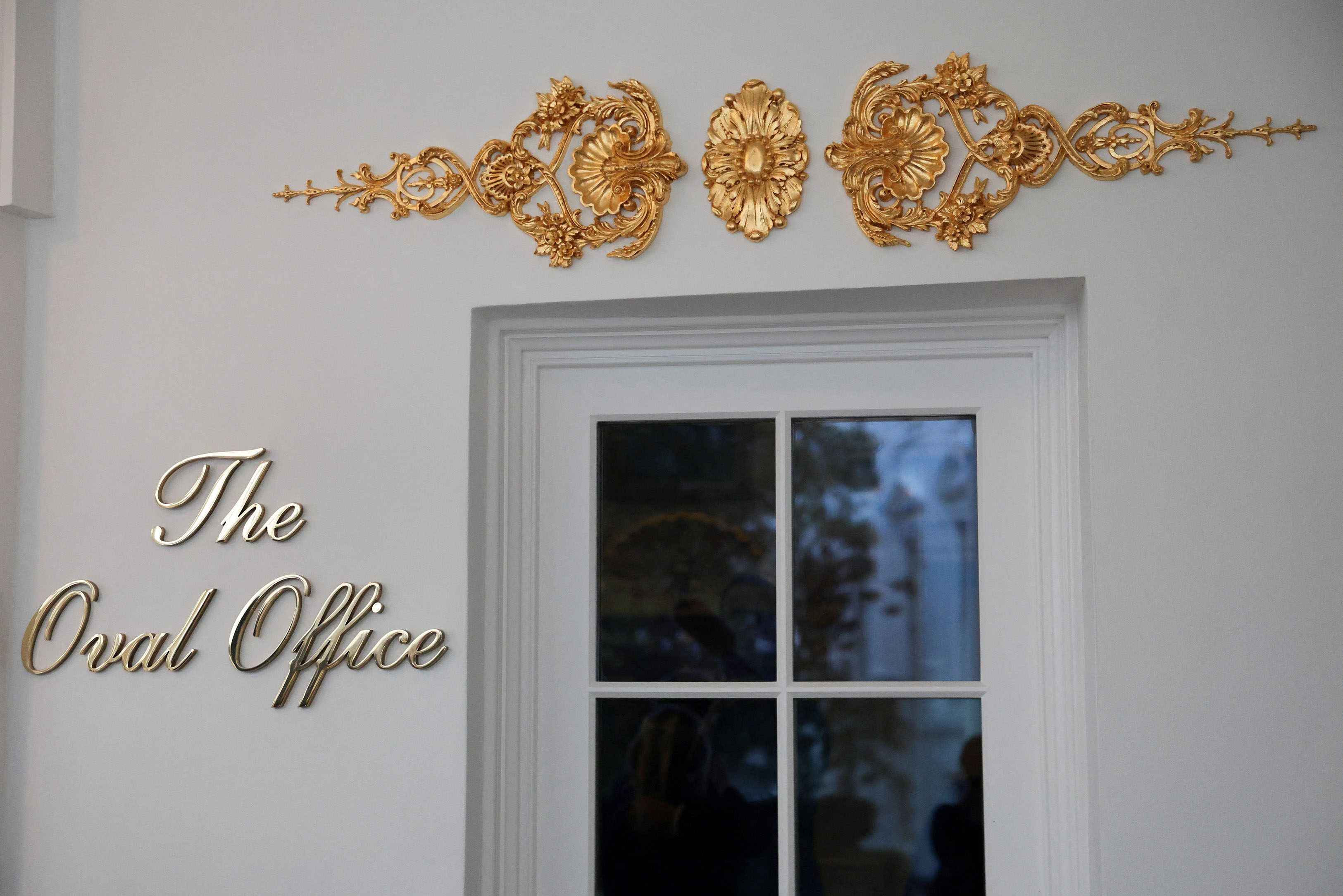 A new sign reading the oval office in cursive script adorns the door at the White House