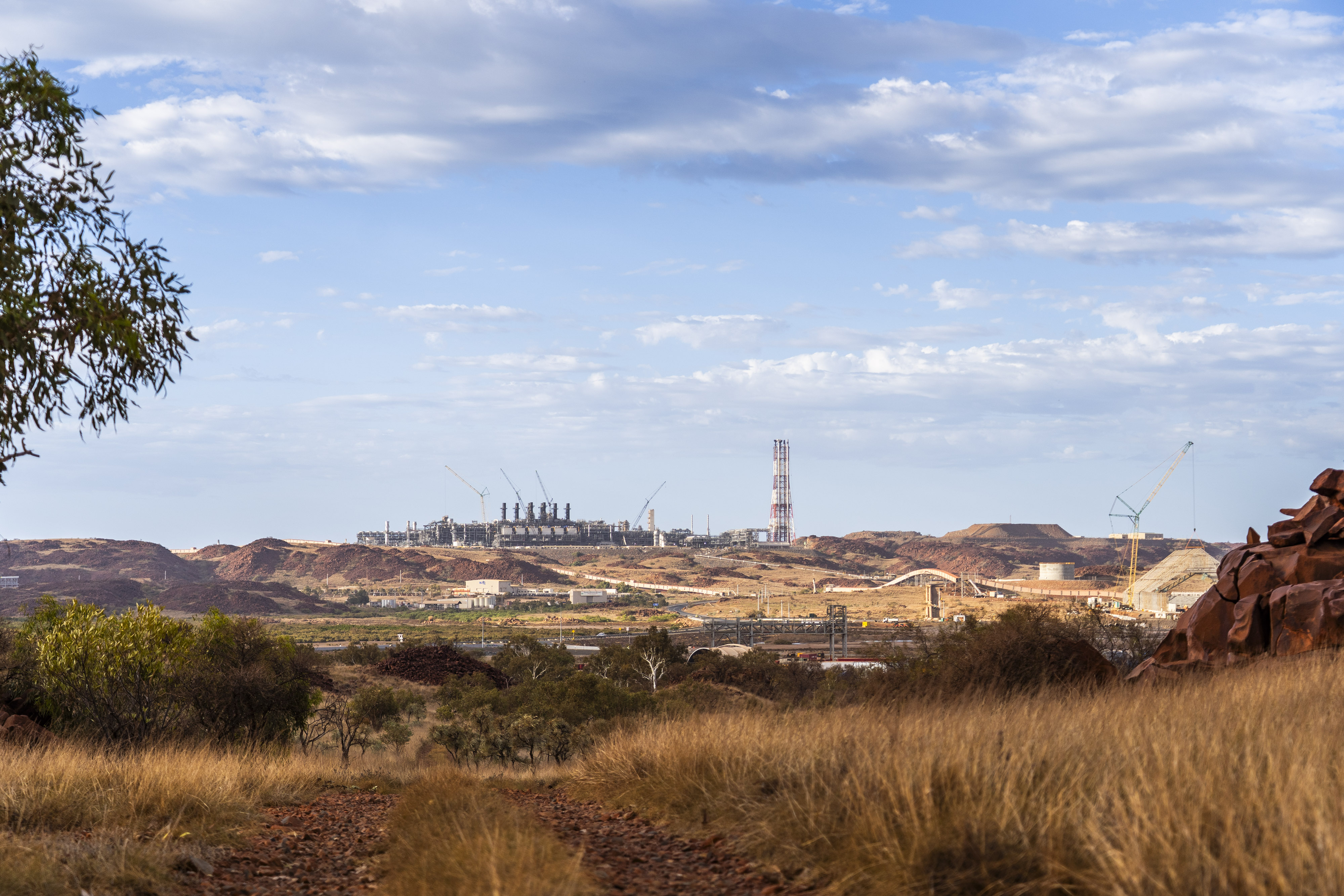 industrial construction with mining and cranes in the distance surrounded by a red rock landscape