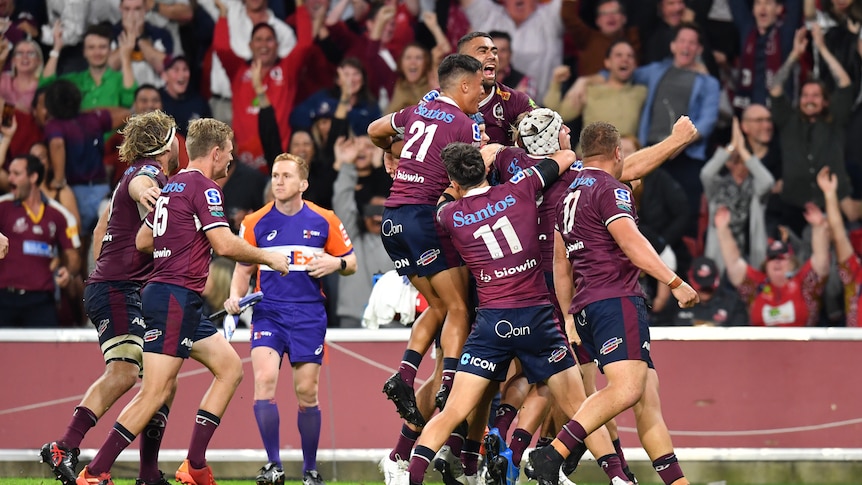 A group of Super Rugby AU players leap into each others arms after winning the competition final.