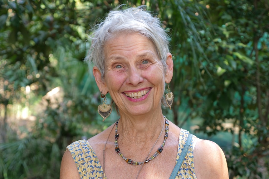 Close up shot of a middle-aged woman smiling enthusiastically at the camera.