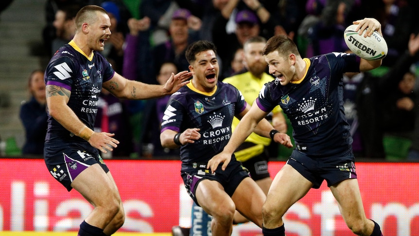 Ryley Jacks throws the ball down as he celebrates a try with his Melbourne Storm teammates.