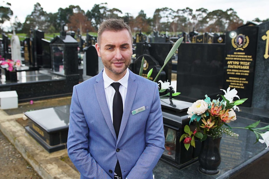 Funeral home owner Michael Cox stands in cemetery.