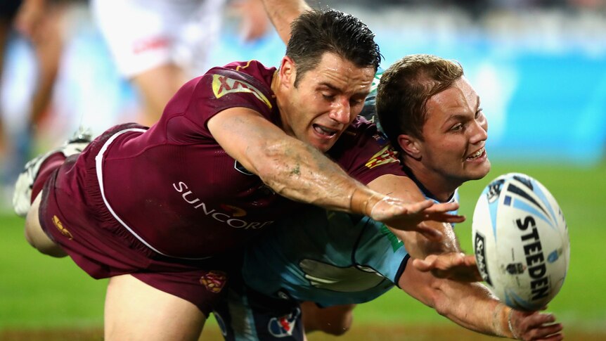 Queensland's Cooper Cronk and the Blues' Matt Moylan compete for the ball