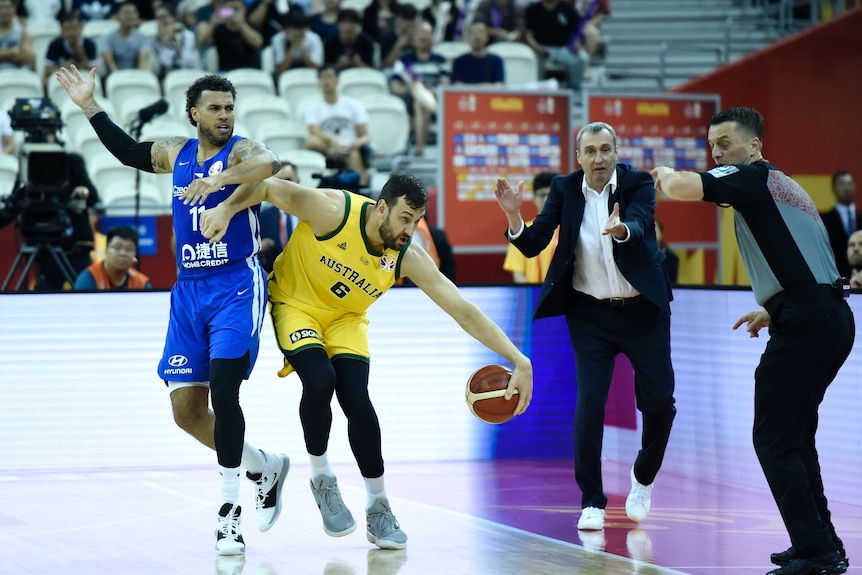 Players flight for a basketball on the court with the Czech Republic standing on the sidelines.