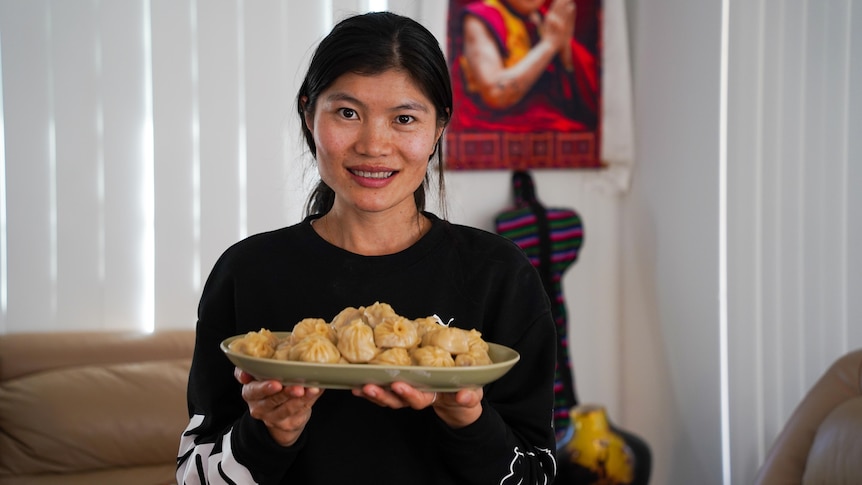 Sonam Lhamo with a plate of dumplings