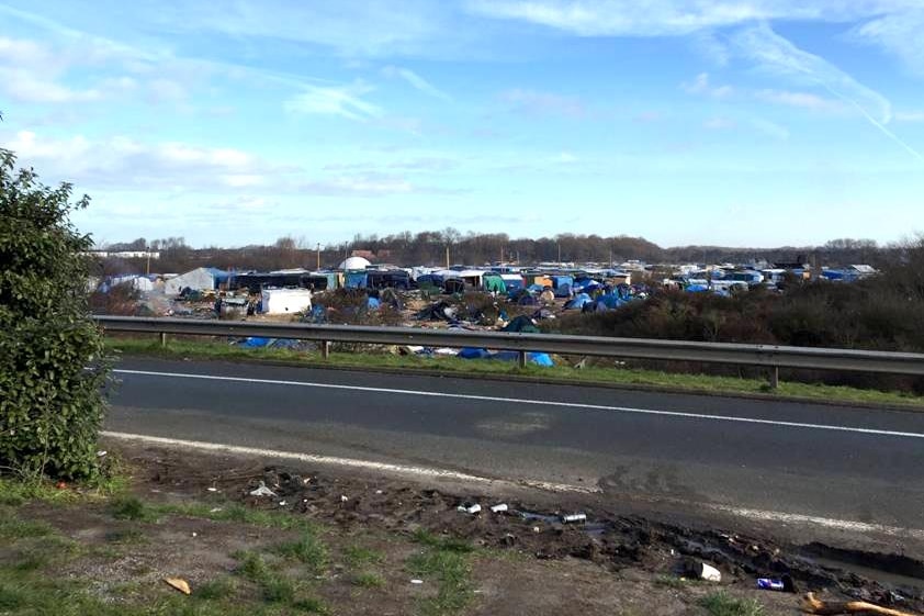 The highway where trucks pass next to the refugee camp, in the distance.