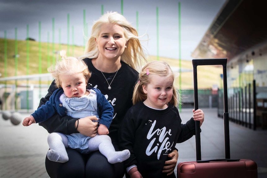 Emily Myors of Brisbane with nieces, Nina and Sadie Myors at Hobart Airport.