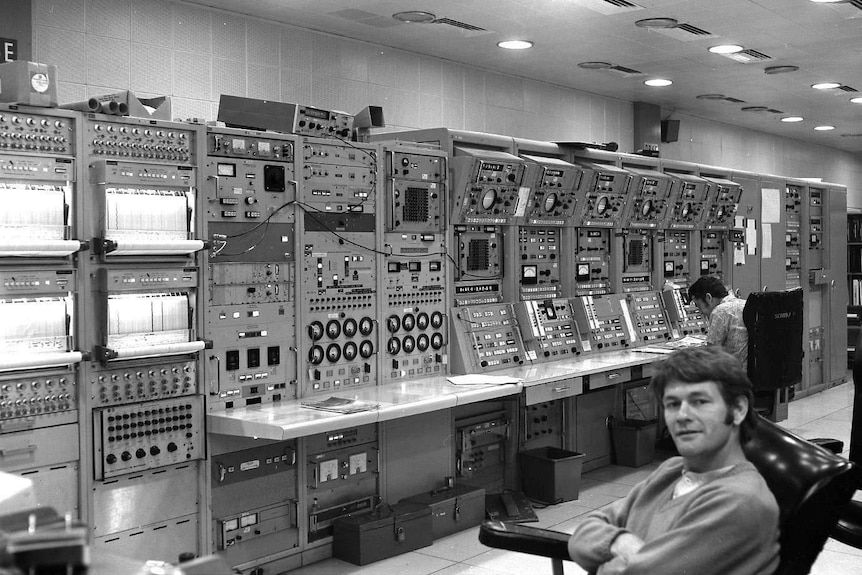 Kevin Gallegos sits in front of a wall of computers at Honeysuckle Creek Tracking Station.