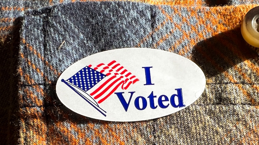 A white sticker with an American flag which says 'I voted'.  