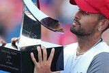 Nick Kyrgios holds the Donald Dell Trophy after winning the Washington Open