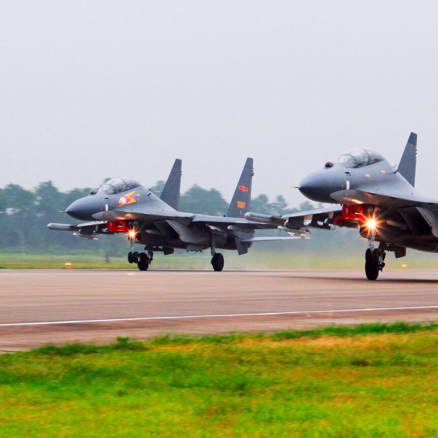 Two fighter jets take off from a runway