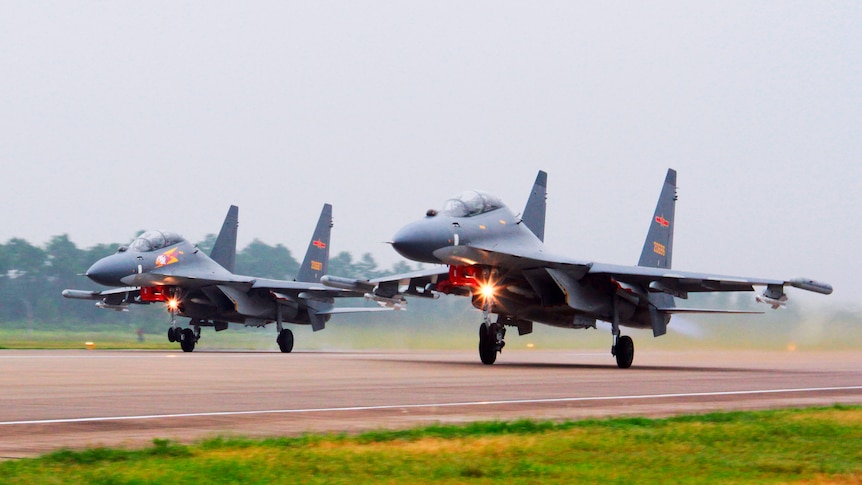 Two fighter jets take off from a runway