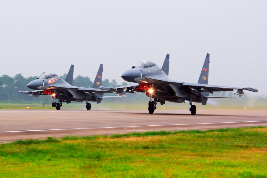 Two fighter jets take off from a runway