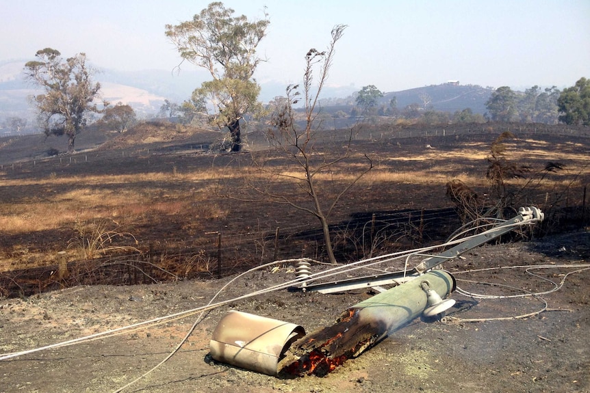 Fire burns inside a power pole after the bushfire in Forcett.