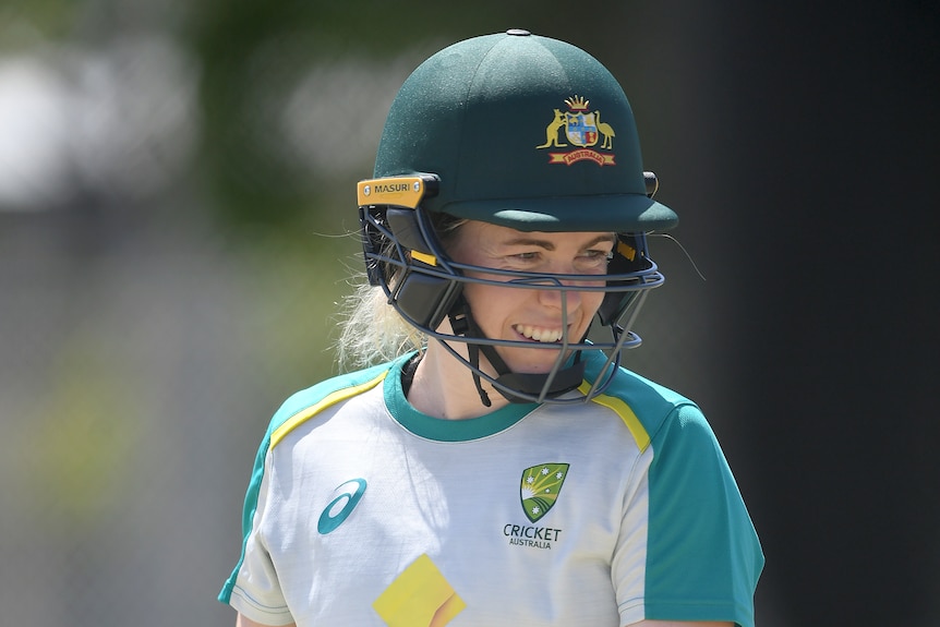 Wicketkeeper Georgia Redmayne smiles with her helmet and gloves on while training on the cricket field