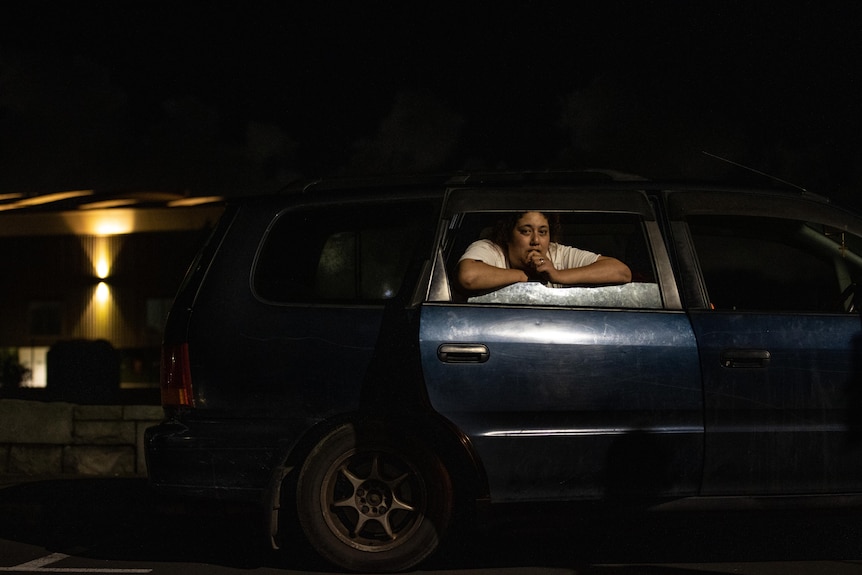 An exterior shot of the car with Ebony leaning on the rear window frame. 