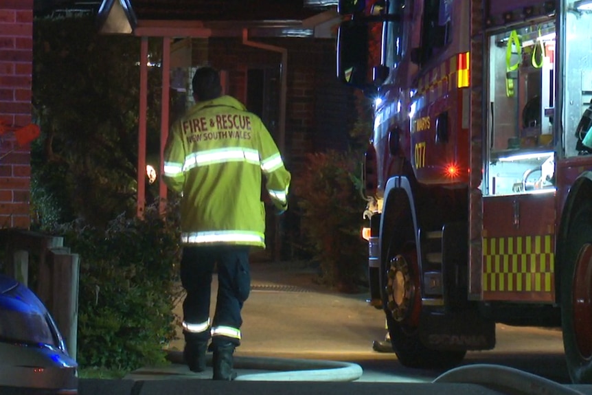 firefighter walking into a dark house