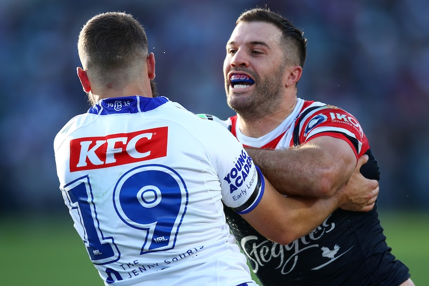 A Sydney Roosters NRL player is tackled by a Canterbury opponent.