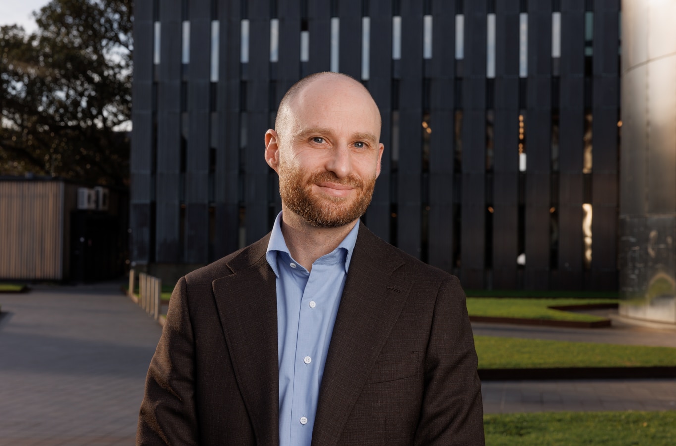 Hombre calvo con barba, traje y camisa azul