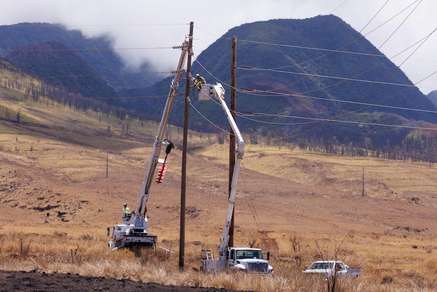 Electrical workers repair power lines leading into the fire ravaged town of Lahaina on the island of Maui in Hawaii.