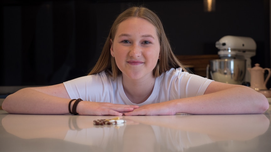 Mae Johnson with her daily dose of medicine on the table in front of her.