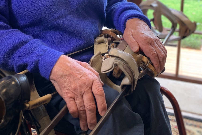A close up of a middle-aged white man's hands. They are holding crutches