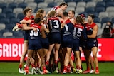 A group of Melbourne players pile on top of Max Gawn who has just kicked the winning goal after the siren.
