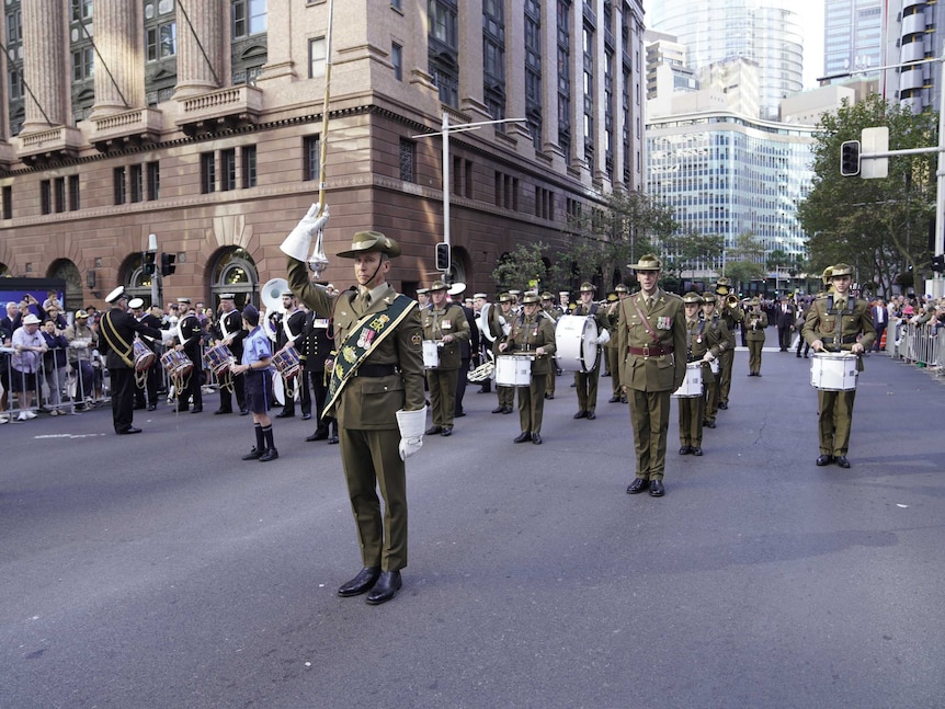 Soldiers dressed un uniform, holding instruments, ready to start the Anzac Day march in Sydney.