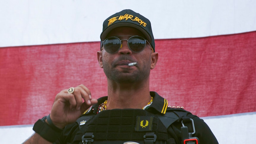 Proud Boys leader Henry "Enrique" Tarrio wears a hat that says The War Boys during an earlier rally.