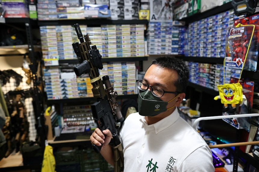 Lin Ping-yu displays of one of his 12 airsoft guns at his home in New Taipei City.