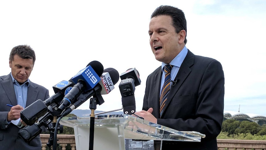 Nick Xenophon standing behind a podium that says SA Best