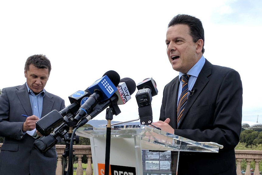 Nick Xenophon standing behind a podium that says SA Best