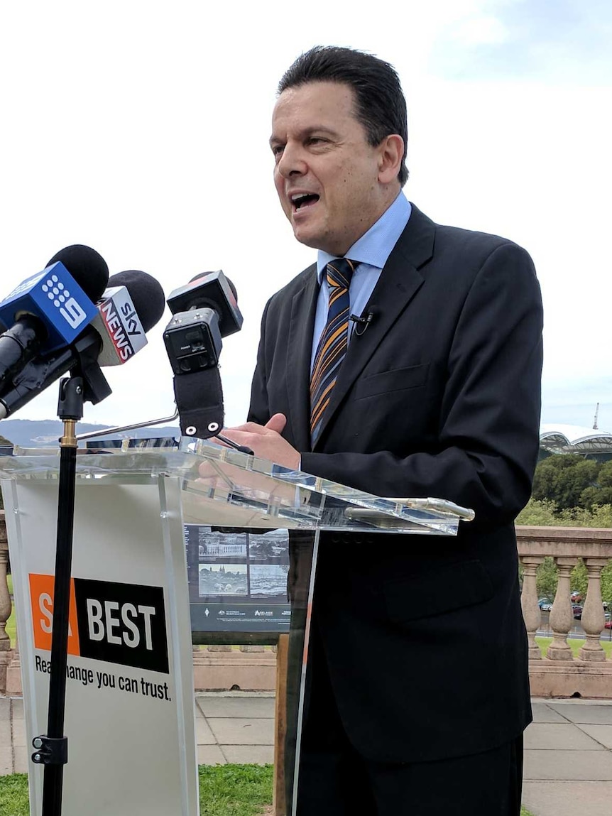 Nick Xenophon standing behind a podium that says SA Best